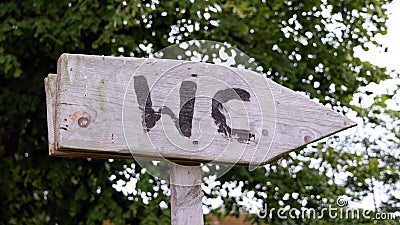 Wooden signpost showing the way to the toilet Stock Photo