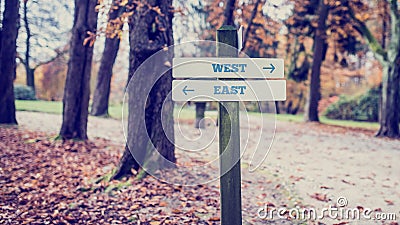 Wooden Signpost for West and East Directions Stock Photo