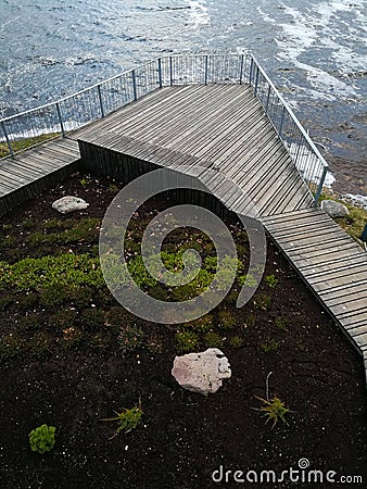 Wooden site in front of the river. Wooden walkboard with a fence. Top view. Stock Photo