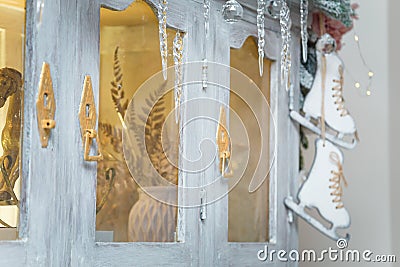 Wooden skates toy hanging on cupboard decorated with fir branches, icycles and snowy roses. merry Christmas decorated elements Stock Photo