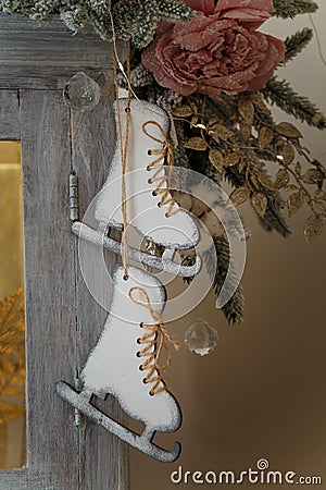 Wooden skates toy hanging on cupboard decorated with fir branches, icycles and snowy roses. merry Christmas decorated elements Stock Photo