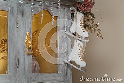 Wooden skates toy hanging on cupboard decorated with fir branches, icycles and snowy roses. merry Christmas decorated elements Stock Photo