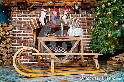 wooden sleds and socks for a gift from Santa Claus hang on the fireplace. Stock Photo