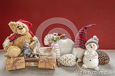 Wooden sleigh with a teddy bear, snowman, pixy, candy cane, Christmas baubles, children, pine cones and gifts Stock Photo