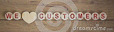 Wooden small circles with words we love customers on wood background. Concept image Stock Photo