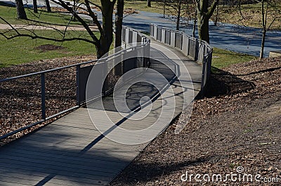 Wooden smooth surface of the ramp for wheelchairs, cyclists and mothers with prams. wooden planks and metal lattice fill the raili Stock Photo