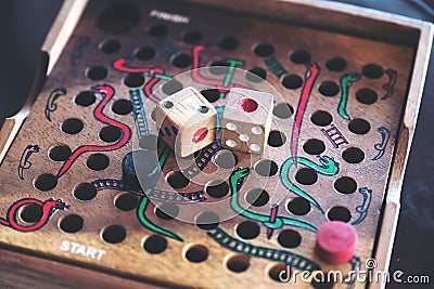 A wooden Snakes and Ladders game Stock Photo