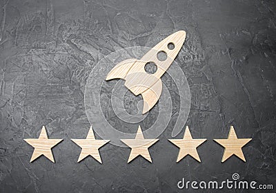 A wooden space rocket and five stars on a concrete background. The concept of space travel, commercial launches into space. Stock Photo
