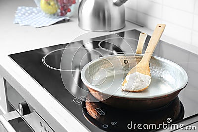 Wooden spatula with coconut oil in frying pan Stock Photo