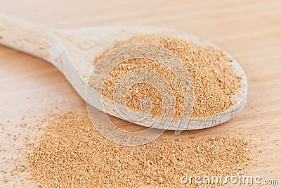 Wooden spoon filled with grated nutmeg Stock Photo