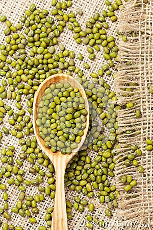 Wooden spoon with heap of raw green organic mung Stock Photo