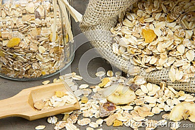 wooden spoon with muesli and burlap sack and jar on the background Stock Photo