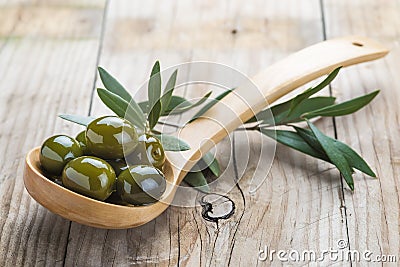 Wooden spoon with olives and oil Stock Photo