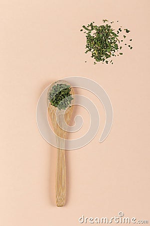 Wooden spoon with Parsley on pink background Stock Photo