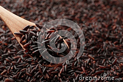 Wooden spoon with raw brown rice over cereal Stock Photo