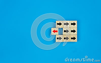 Wooden square block the red arrow symbol turns to the opposite direction of black arrows symbol Stock Photo