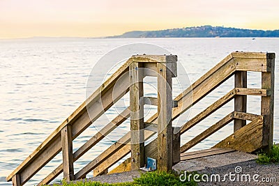 Wooden stair rails leading down to water in Pacific Northwest Stock Photo