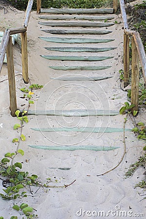 Wooden staircase covered by beach sand on tropical summer Stock Photo