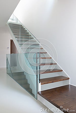 Wooden stairs with glass balustrade Stock Photo