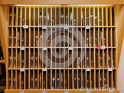 Wooden stand showcase with Cutlery spoons, forks and knives made of precious metals in the shopping center Gallery Editorial Stock Photo
