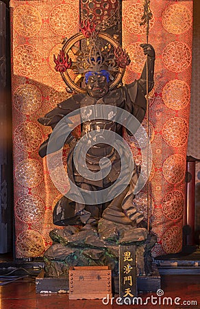 Wooden statue depicting one of the Four Heavenly Kings buddhist deity of Bishamonten depicted holding a lance in the Tendai Editorial Stock Photo