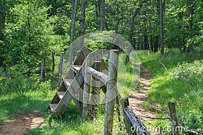 Wooden Stile Crossing a Fence in a Mountain Meadow Stock Photo