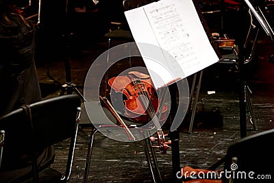 wooden stringed instrument violin lies on a chair Stock Photo