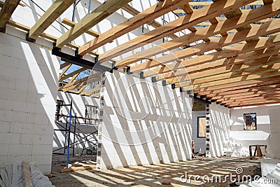 The wooden structure of the building. Installation of wooden beams at construction the roof truss system of the house. Stock Photo