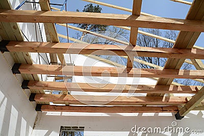 The wooden structure of the building. Installation of wooden beams at construction the roof truss system of the house. Stock Photo