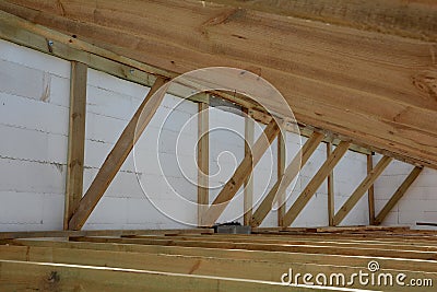 The wooden structure of the building. Installation of wooden beams at construction the roof truss system of the house. Stock Photo