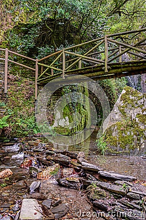 Wooden suspension bridge on hill, water and schist rocks of Barroca de DegraÃ­nhos river in Fraga de Pena, Arganil PORTUGAL Stock Photo