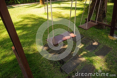 Wooden swing hanging in a beautiful garden near the bungalow. The inner territory of a beautiful hotel on the seafront. Small Stock Photo