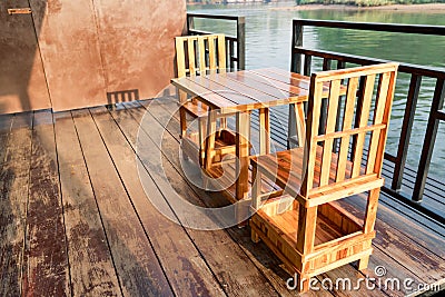 Wooden table and chair on the terrace near the river in the morning scene Stock Photo