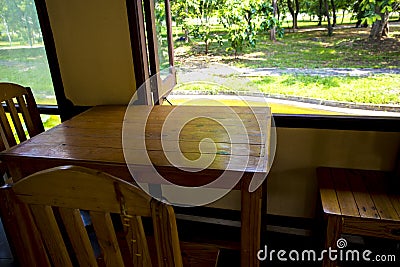 Wooden table and chairs put beside the windows. Sunlight is shine on the table and chair make comfortable zone and relax. The tabl Stock Photo