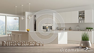 Wooden table, desk or shelf with potted grass plant, house keys and 3D letters making the words interior design, over blurred mini Stock Photo