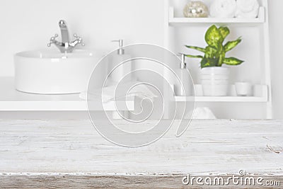 Wooden table in front of blurred white bathroom shelves background Stock Photo