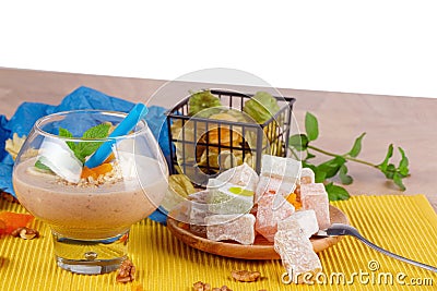 A glass of cocktail, fresh mint, dried apricot, walnuts, plate of rahat lokum or lokum, physalis, isolated on a white Stock Photo