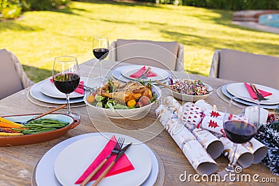 A wooden table prepared for a meal in the sunny garden Stock Photo
