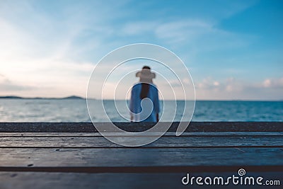 Wooden table with the sea and blue sky background and a blur woman Stock Photo