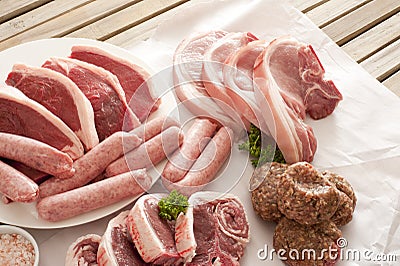 Wooden table set with selection of meat cuts Stock Photo