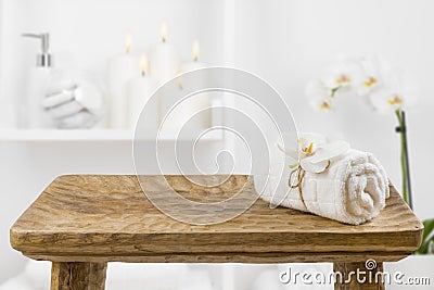 Wooden table with spa towel on blurred bathroom shelf background Stock Photo