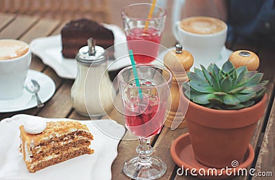 Wooden table on summer terrace with cake, berry juice, succulent Stock Photo