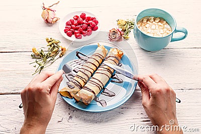 Wooden table with twisted pancakes Stock Photo