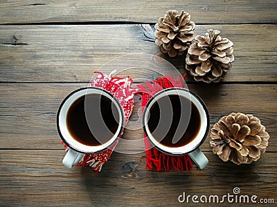 On the wooden table are two cups of Americano and three cones. winter coziness. Stock Photo