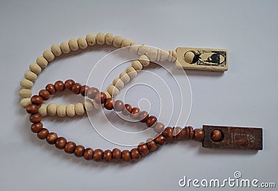 Wooden tasbeh a tool for calculating wirid, moslem prayer. Brown and cream tasbeh beads on white background. Stock Photo