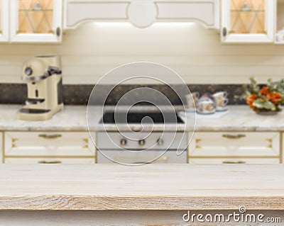 Wooden textured table over blurred kitchen stove interior background Stock Photo