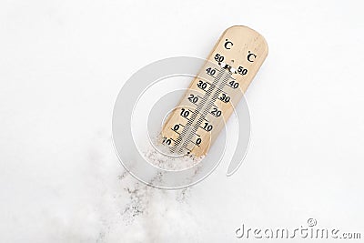 Wooden thermometer on snow shows low temperature below zero in celsius degrees scale. Winter frost. Weather forecast Stock Photo