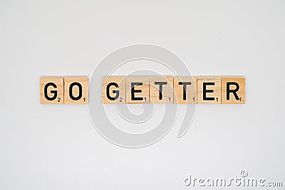 Wooden tile spelling the words go getter on a white background Stock Photo