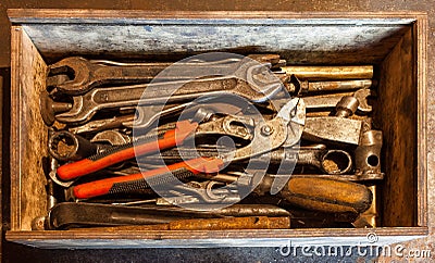 The wooden tool box of hand tools with old and dirty, rusty wrenches, ring spanners, pliers, screwdrivers, chisel and other Stock Photo