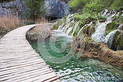 Wooden tourist pathway passing through waterfalls Stock Photo